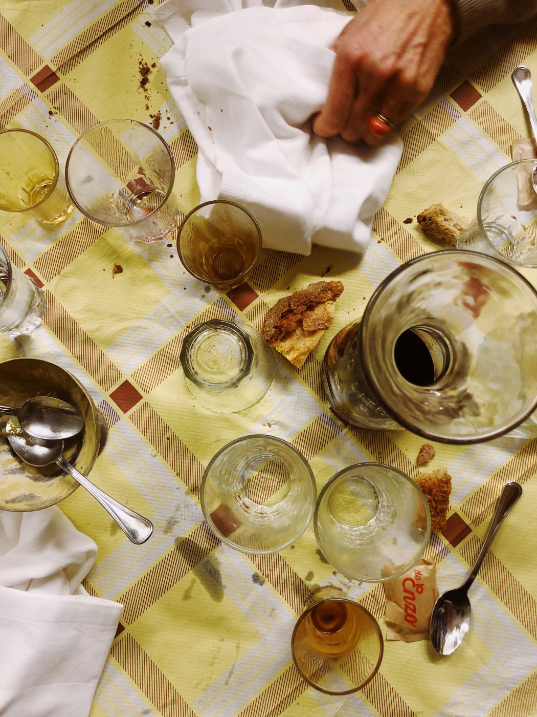 Table full of cups and wine splashed while a hand cleaning with a cloth in Da enzo al 29 in Rome Lazio in Italy