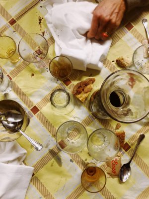 Table full of cups and wine splashed while a hand cleaning with a cloth in Da enzo al 29 in Rome Lazio in Italy