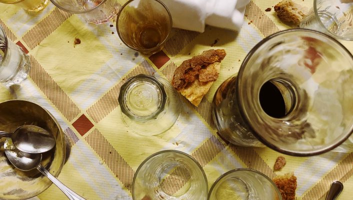 Table full of cups and wine splashed while a hand cleaning with a cloth in Da enzo al 29 in Rome Lazio in Italy