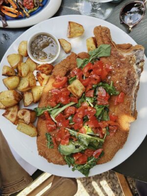 costoletta alla milanese with fresh tomatoes and roasted potatoes