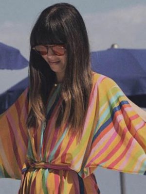 Caterina Licitra Ponti wearing a colorful dress and sunglasses posing in italian beach with blue umbrellas