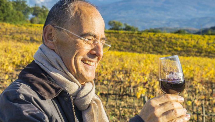 Stefano Cinelli Colombini holding a Wine cup in a vineyard with blue sky