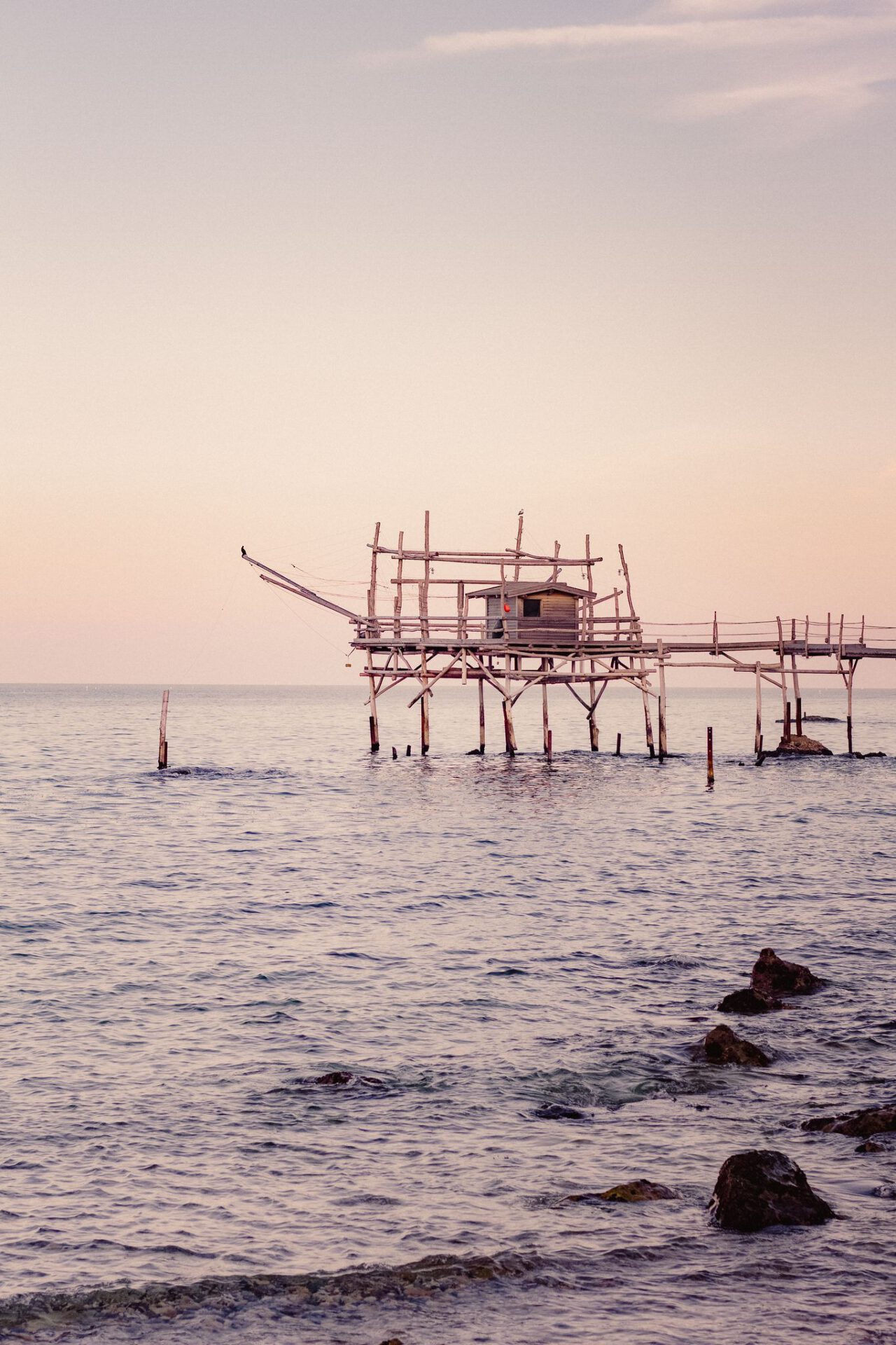 Wooden house over the sea and pink sky in abruzzo in Italy