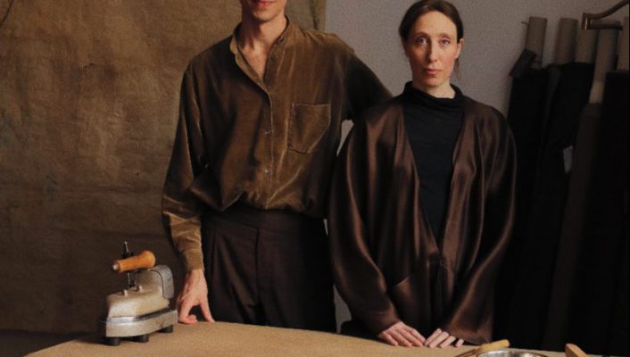 Atelier Bomba team posing in fashion studio with wooden table and fabrics in the background in Rome Italy