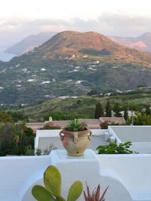 White terrace with plants pots and mountains with sunset backgroung viewed from Hotel Villa Paradiso in Taormina Sicily in Italy