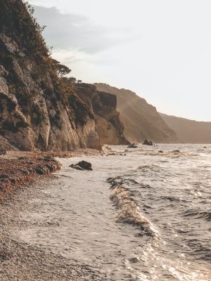 Sided view of beach sea and rocks with sky background at D'Elba island in Tuscany Italy