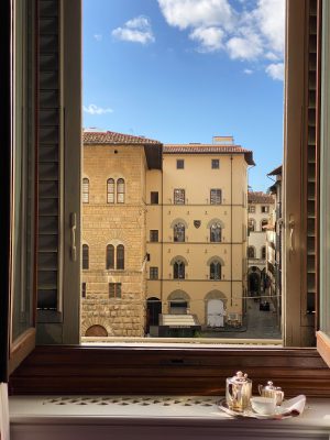 Typical buildings and city streets with blue sky viewed from wooden window at the Helvetia & Bristol hotel in Florence Tuscany in Italy