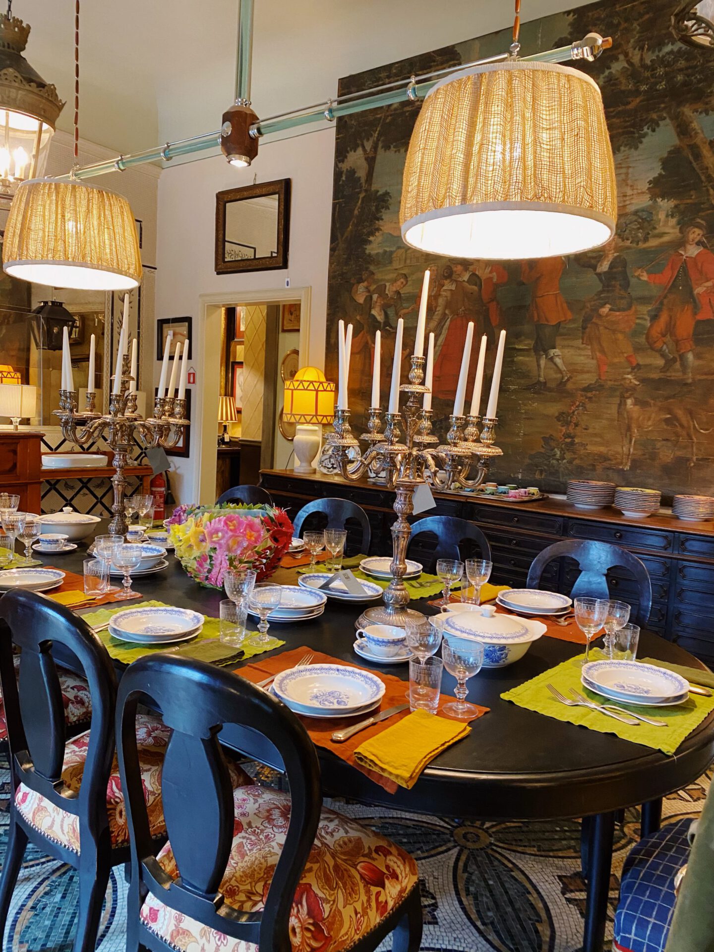 Vintage dinning room filled with wooden furniture and vintage shelves and carpets inside of Riccardo Barthel interior design showroom in Florence Tuscany in Italy