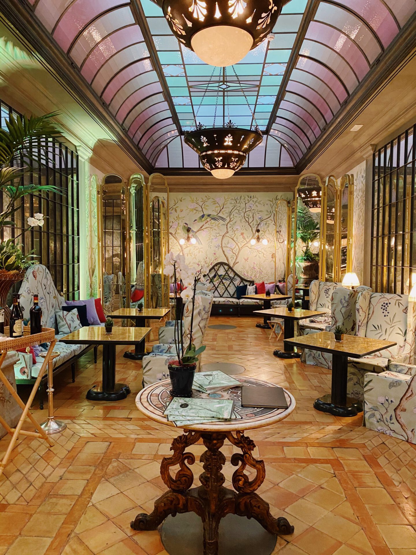 Luxury dinning room with marble tables and patterned chairs with glass walls and roof at the Helvetia & Bristol hotel in Florence Tuscany in Italy