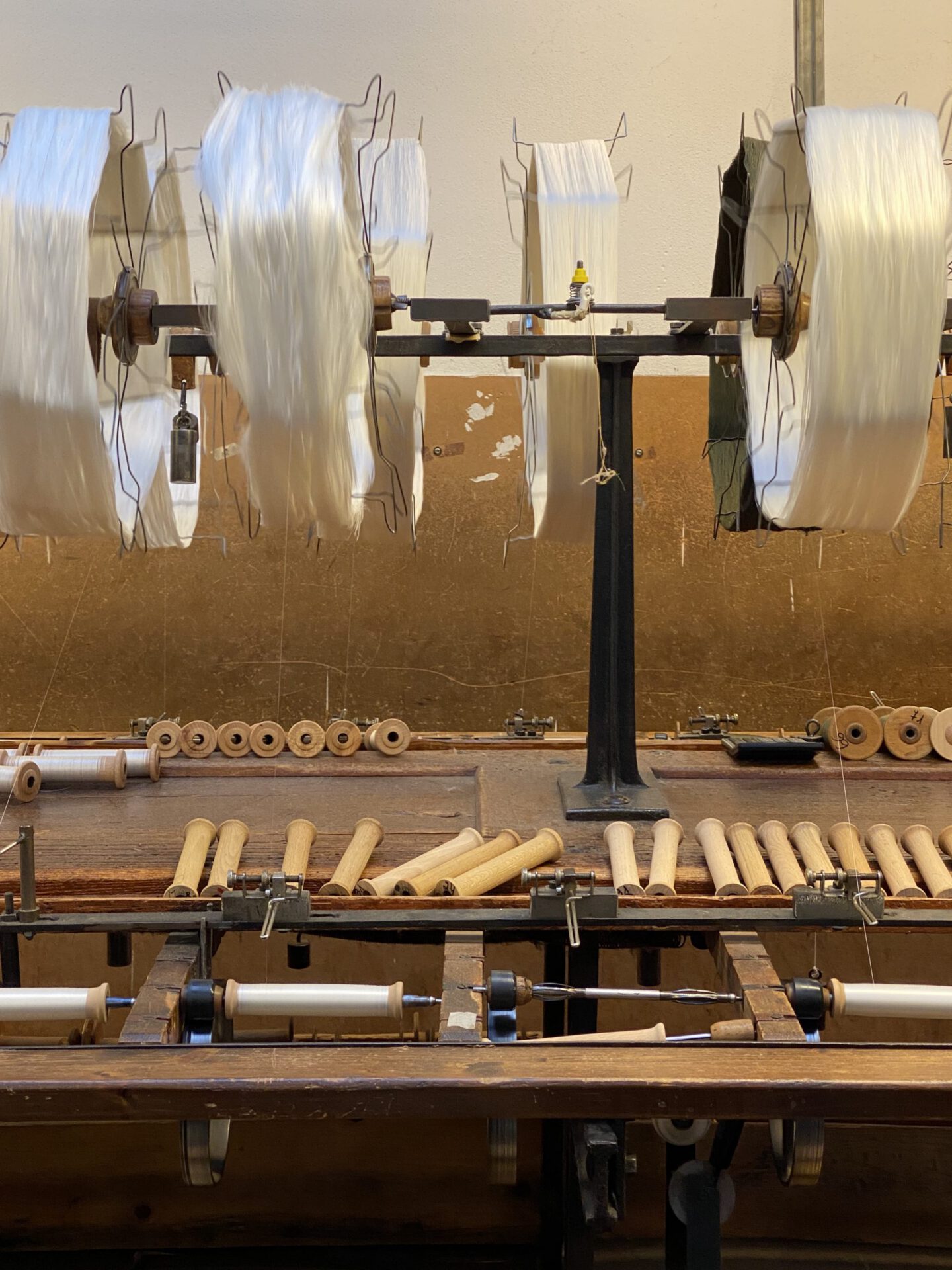 Wooden antique silk warper with white threads in Old Silk Factory Setificio Fiorentino in Florence Tuscany in Italy
