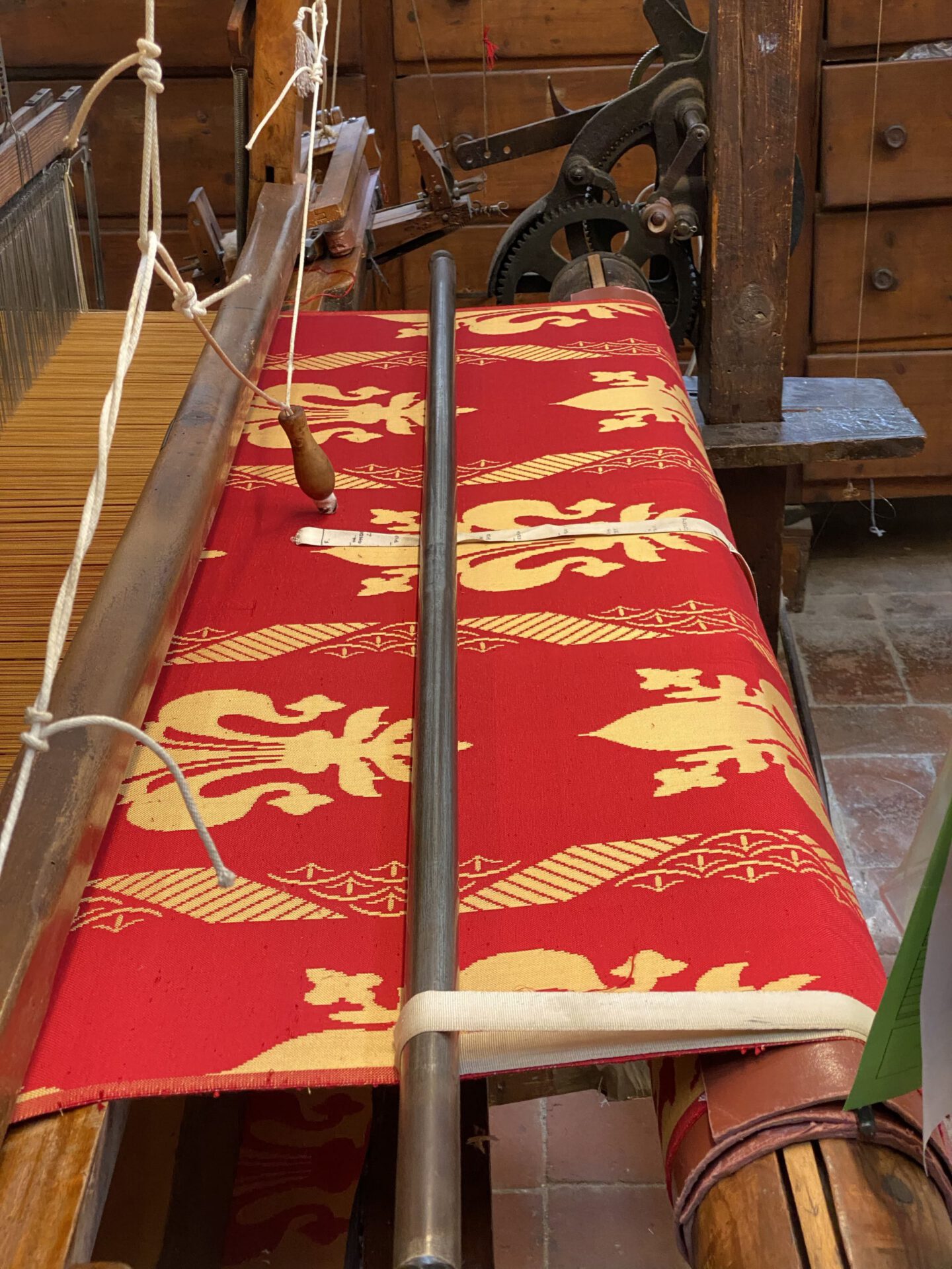 Wooden antique silk warper with red and gold fabric in Old Silk Factory Setificio Fiorentino in Florence Tuscany in Italy