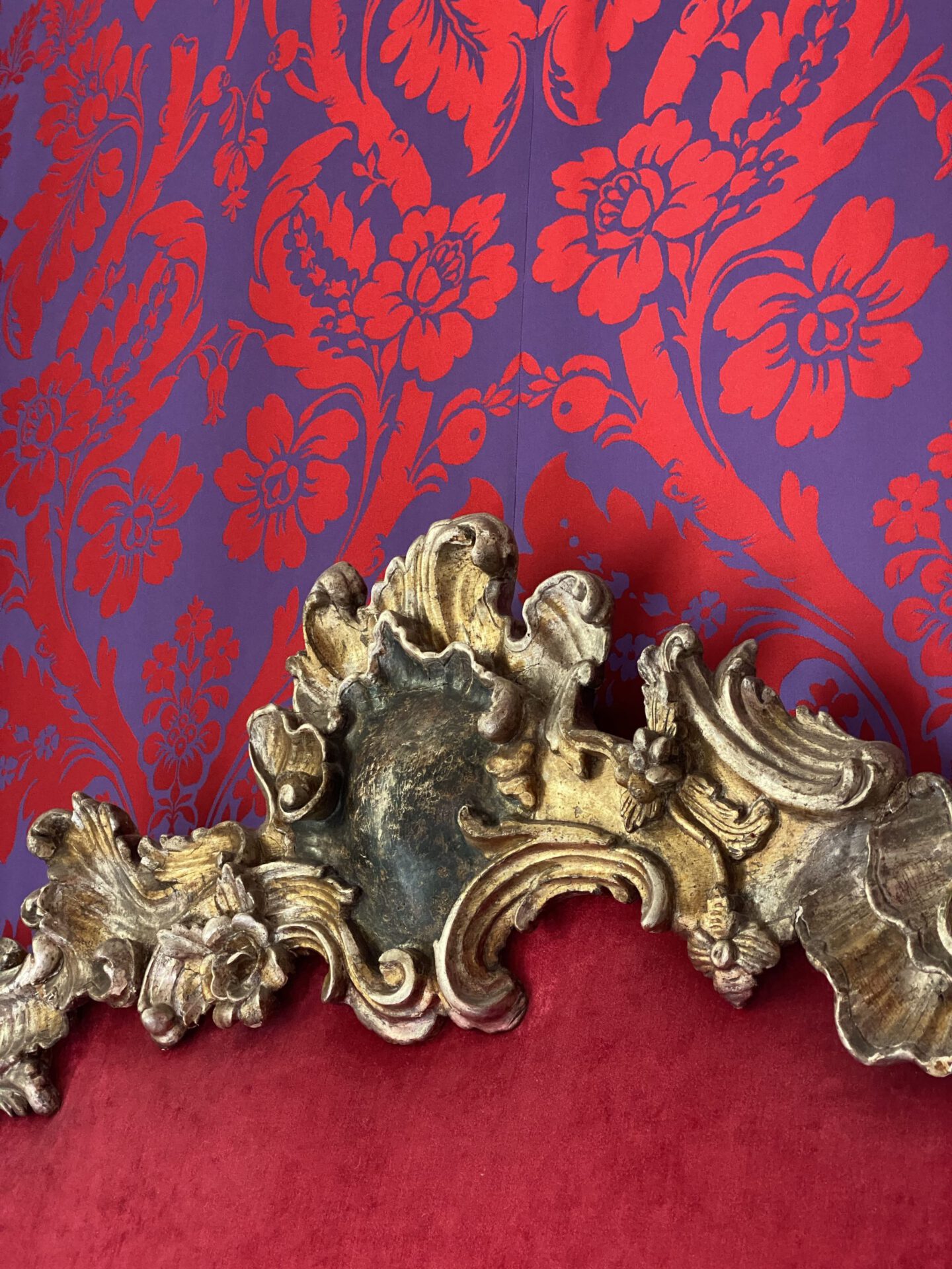 Red and purple flowered pattern wall with antique bed frame of the Helvetia & Bristol hotel in Florence Tuscany in Italy