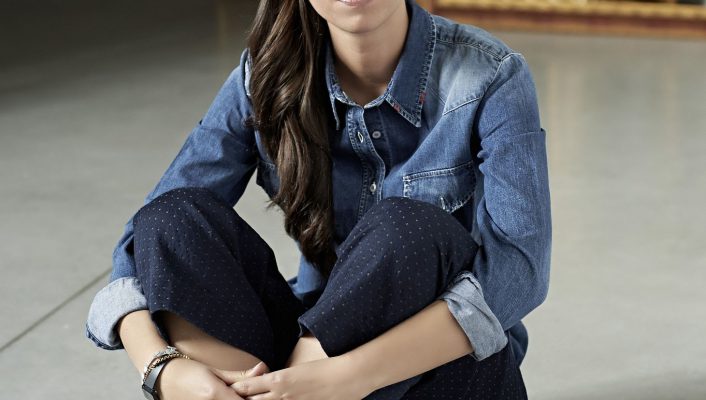 Letizia Palchetti Tosi casual dressed with blue and denim clothes seated in the floor with dark and frames background in Italy