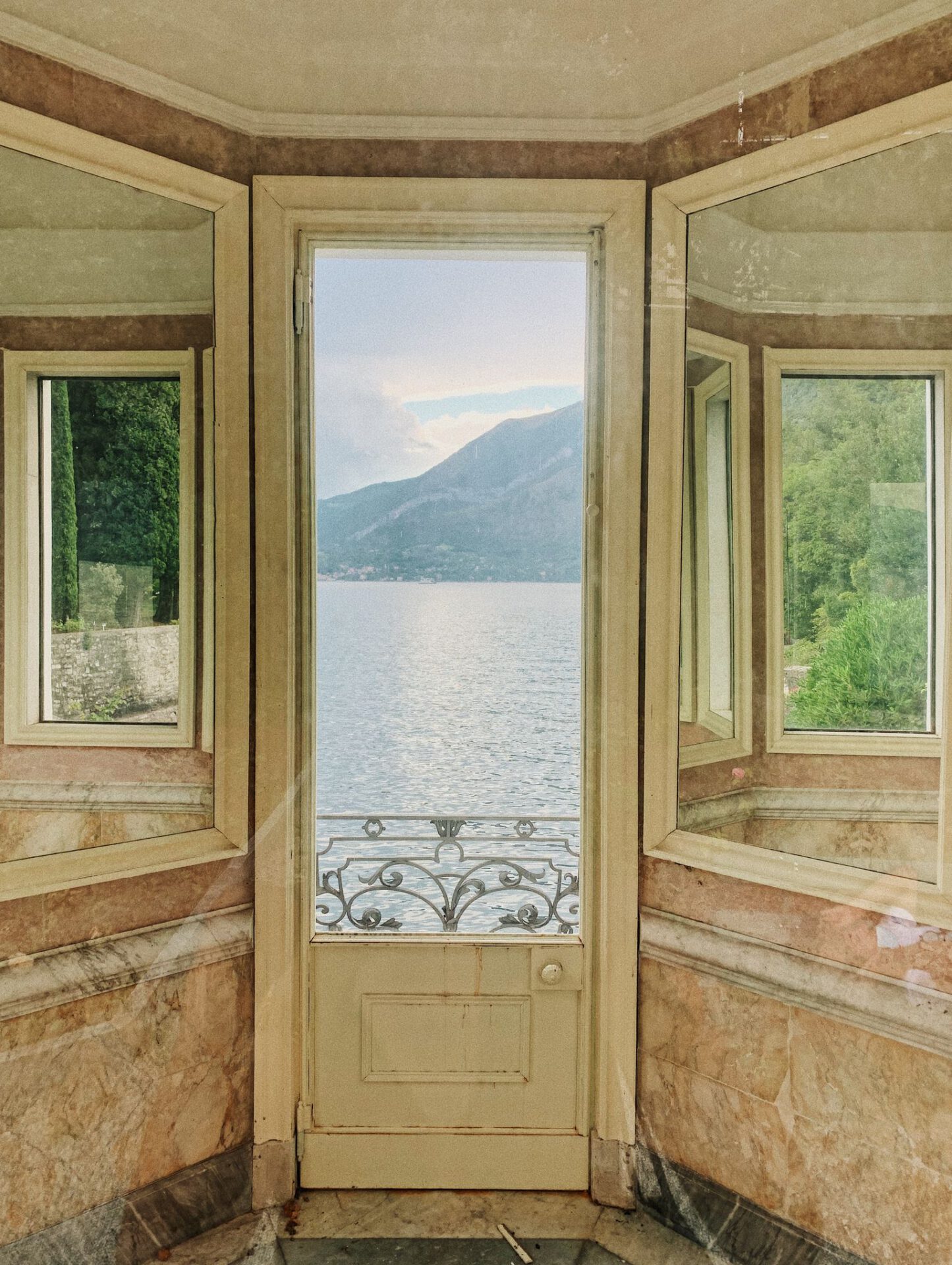 Vintage space with marble and yellow decoration with windows and lake como background in Villa Monastero in Varenna Lombardy in Italy