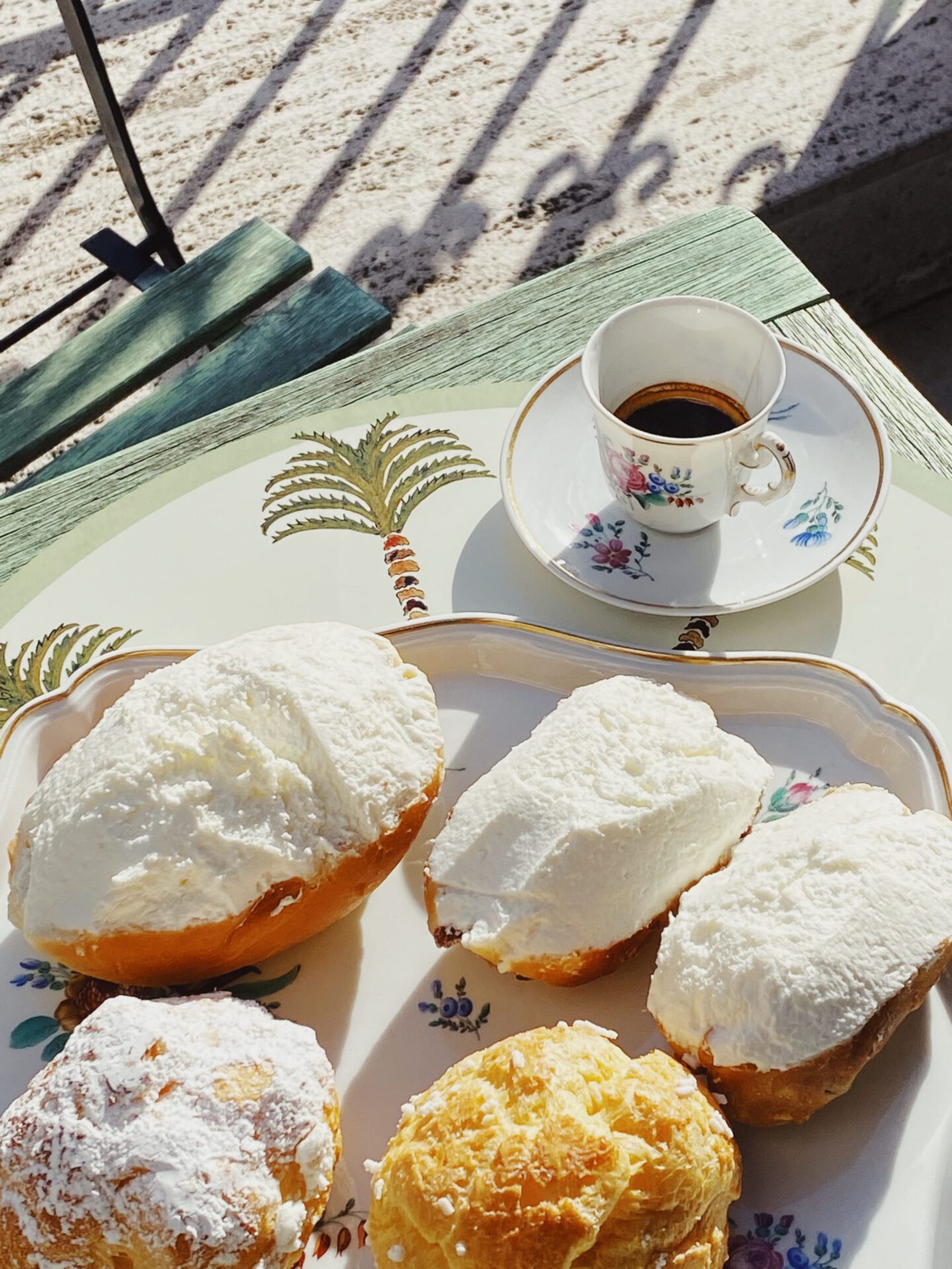 Maritozzi and pastries over ceramic plate and wooden table at Regoli Pastry Shop in Rome Lazio in Italy