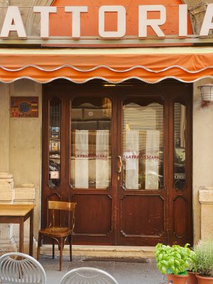Antique trattoria la Francescana with wooden doors and outside tables with chairs in Rome Lazio in Italy