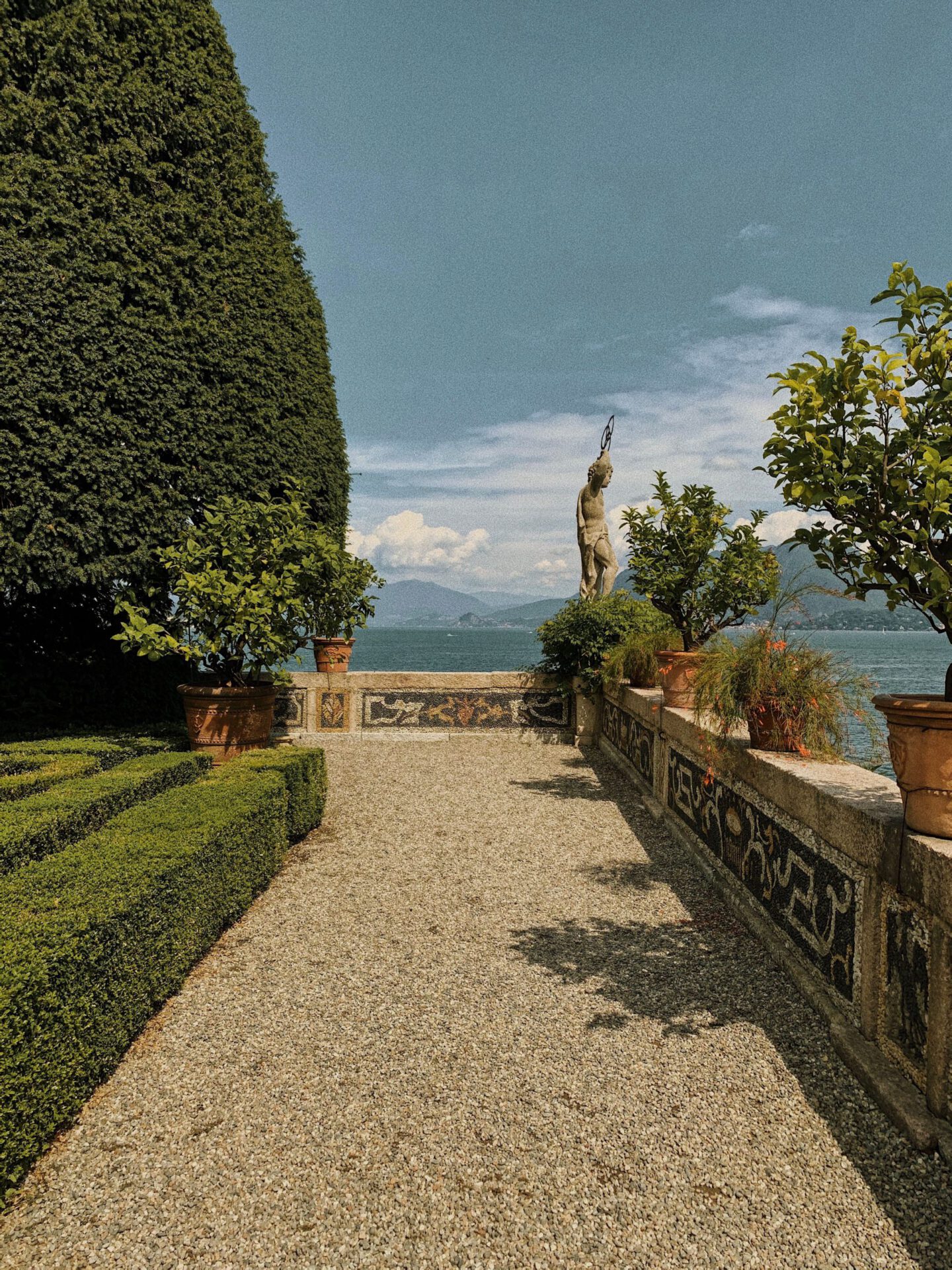 Antique sculpture over a terrace surrounded by plants and geometric fountain in Isola Bella in Lombardy Italy