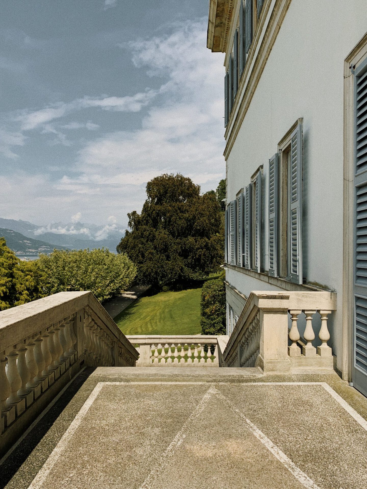 Antique building with staircase surrounded by plants and geometric gardens of Villa Melzi in Bellagio Lombardy in Italy