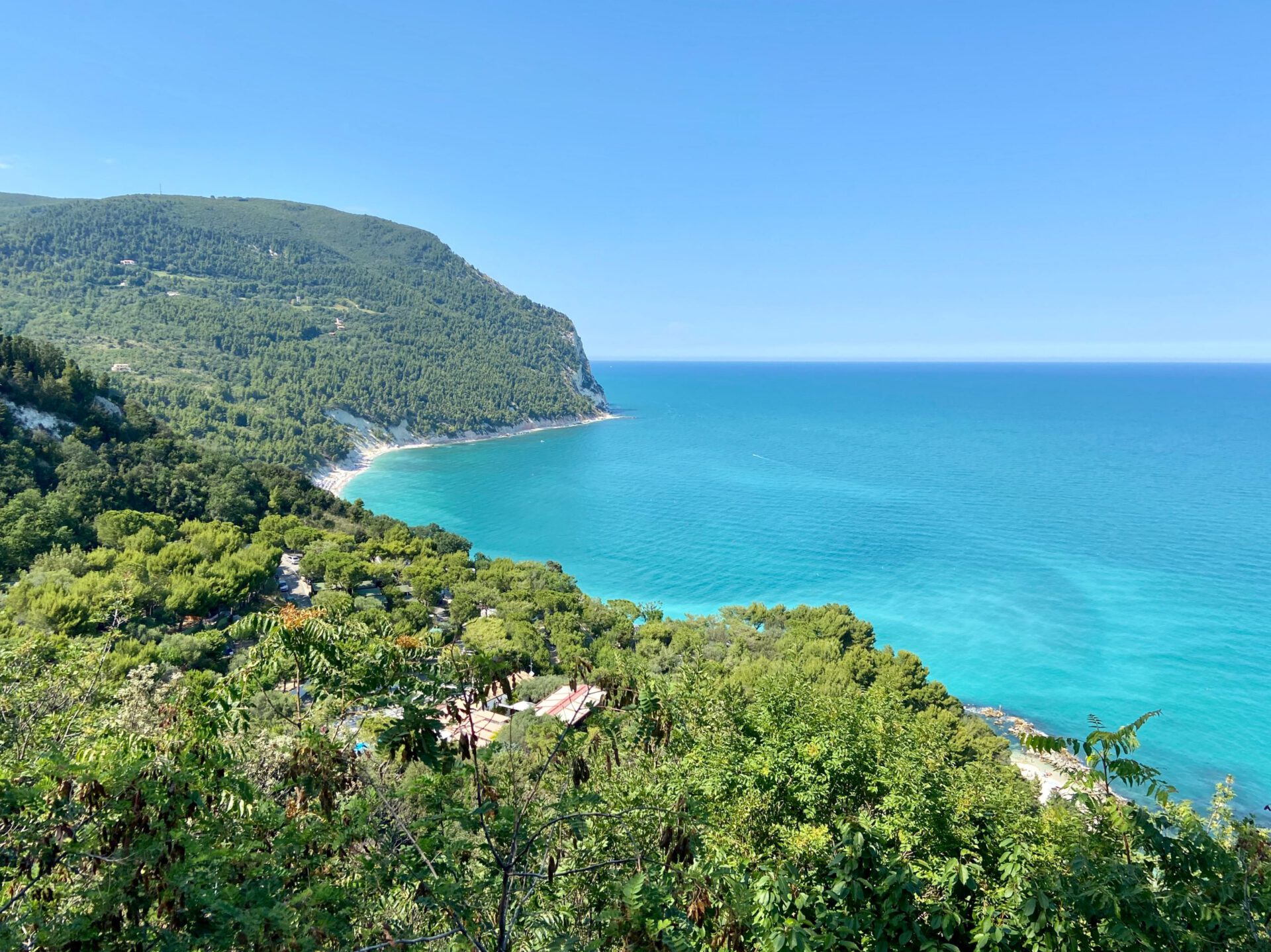 Green mountain landscape with clear blue sea viewed from the top at the Cornero Regional Park in Sirolo le Marche in Italy