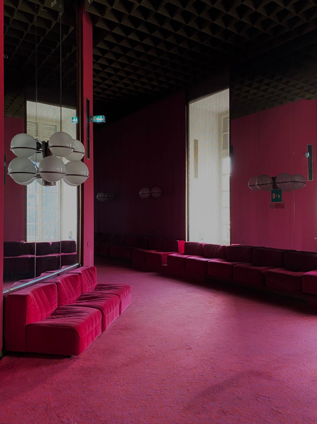 Red furniture carpet and walls with sphere lamps and mirrors at Teatro Regio in Turin Piedmont in Italy