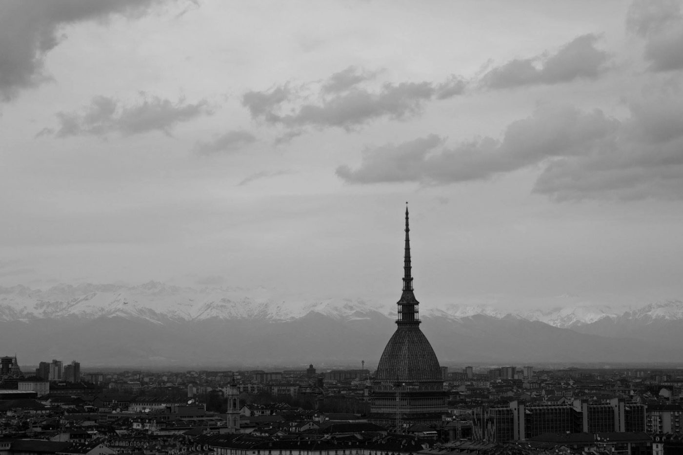 Top view of Turin with Mole Antonelliana building in center roofs and mountains background in Black and White in Piedmont Italy