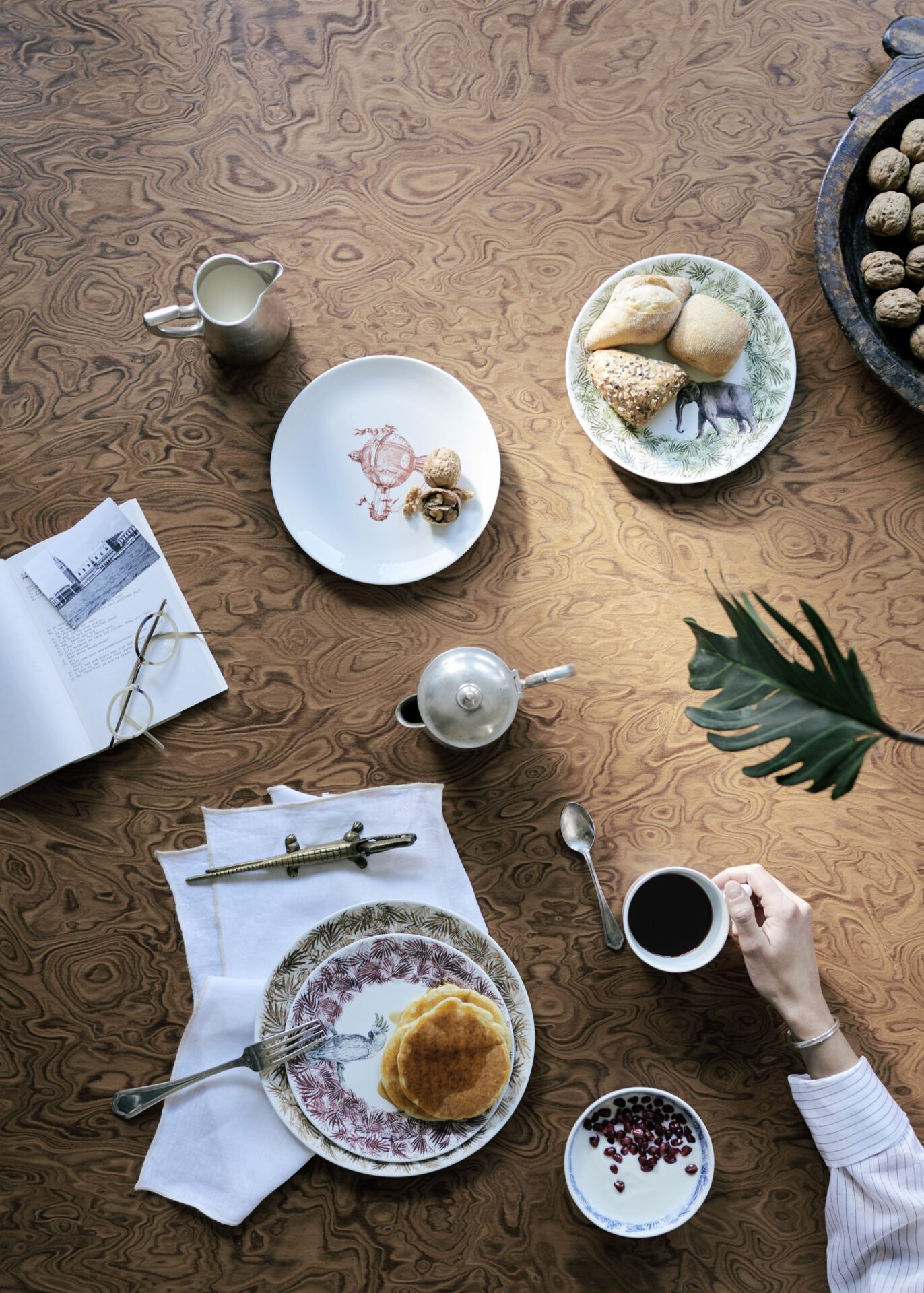 Minimalistic style breakfast over a wooden table with coffee, pancakes and notebook in Hotel Flora in Venice Veneto in Italy