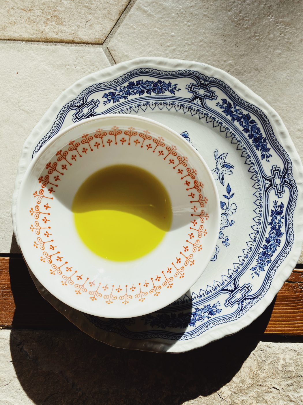 Italian artisan Extra Virgin Olive Oil over ceramic painted plates in Italy