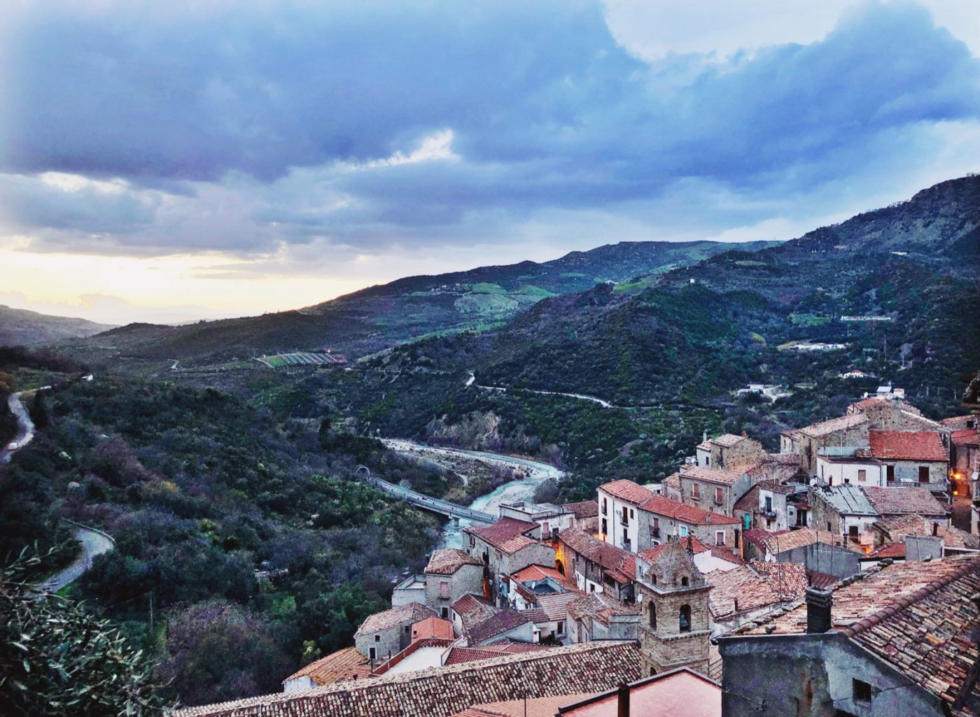 Little town Valsinni viewed from the top next to the Sinni river with green mountains background and big bridge across in Basilicata Italy