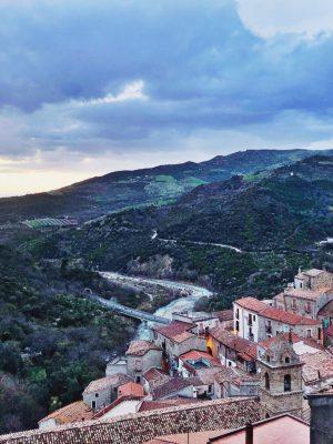 Little town Valsinni viewed from the top next to the Sinni river with green mountains background and big bridge across in Basilicata Italy