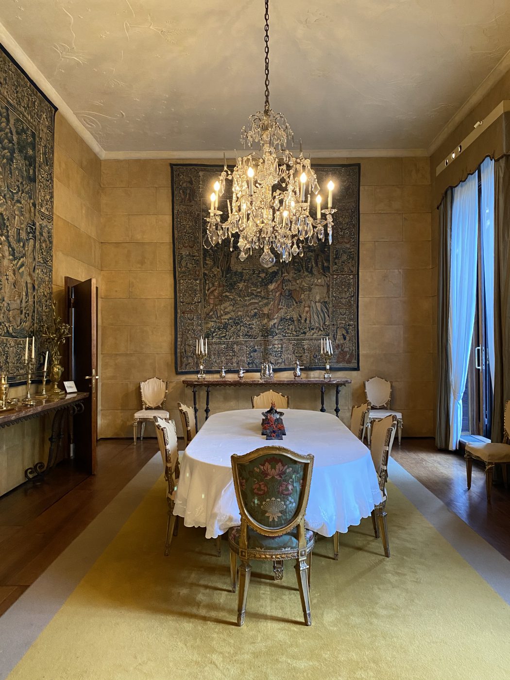 High class style dining room with candle lights hanging and carpets decoration on the walls at Villa Necchi Campiglio in Milan Lombardy in Italy