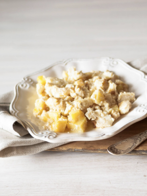 Baccalà Mantecato over a white ceramic plate, kitchen cloth in wooden tray in Italy