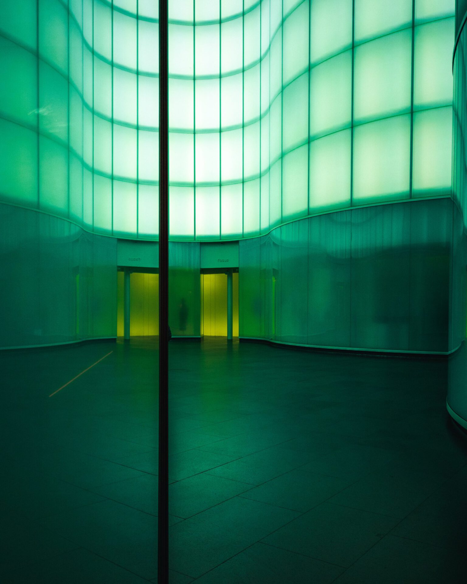 Futuristic exhibition room surrounded by green light panels at the Mudec museum in Milan Lombardy in Italy