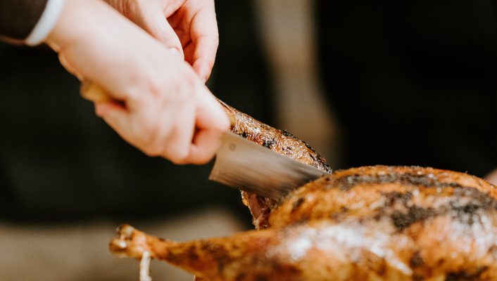 Whole cooked cappone being cut with a knife for Christmas in Italy