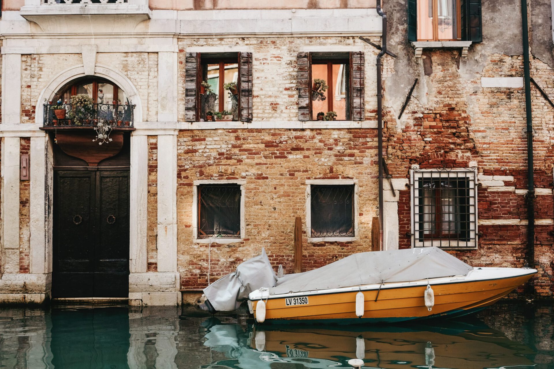 Lateral view of the Grand Canal with a yellow boat and an antique and colorful building in Venice Veneto in Italy
