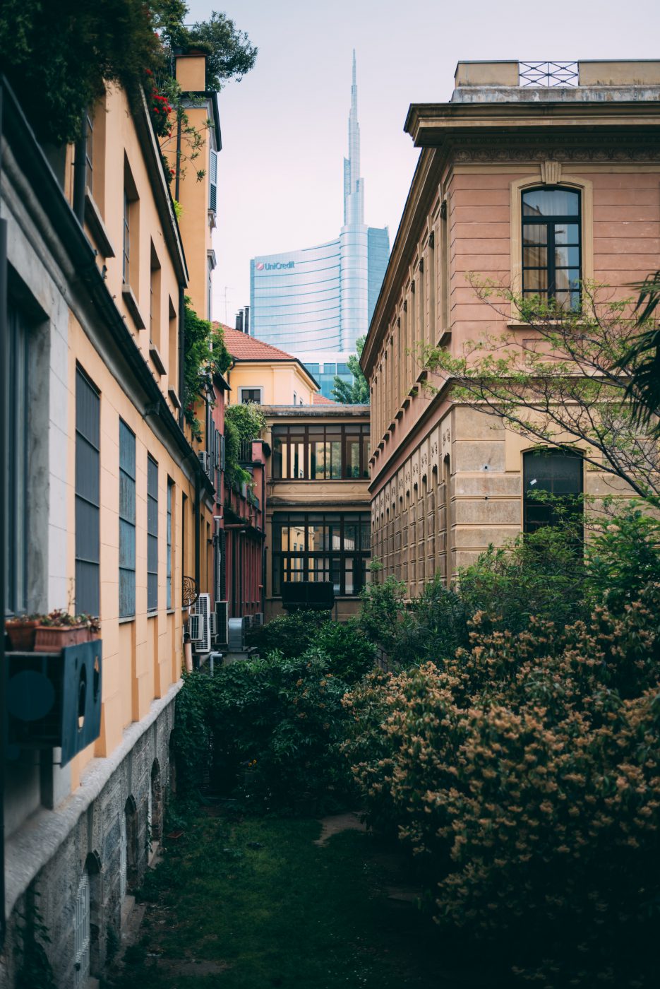 Modern and colorful buildings surrounded by plants and trees with wooden windows and big glass building background in Milan Lombardy in Italy