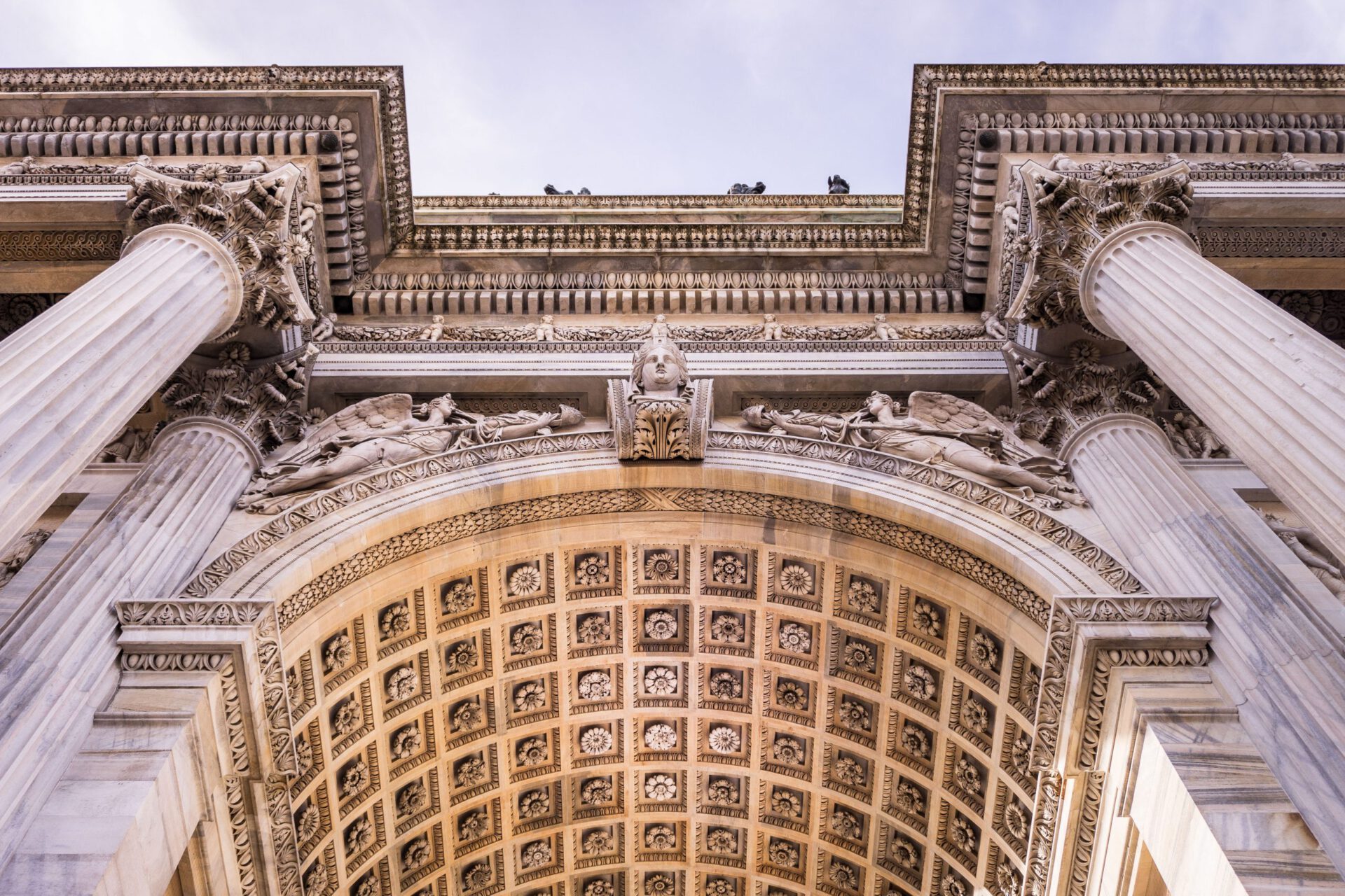 Low view of the Arco della Pace filled with sculpture details, columns and geometrical designs in Milan Lombardy in Italy