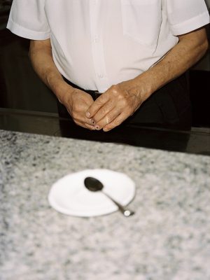 Franco Vitto formal dressed in behind a bar's counter with a little plate and spoon at Caffè dell'Incontro in Conversano Puglia in italy
