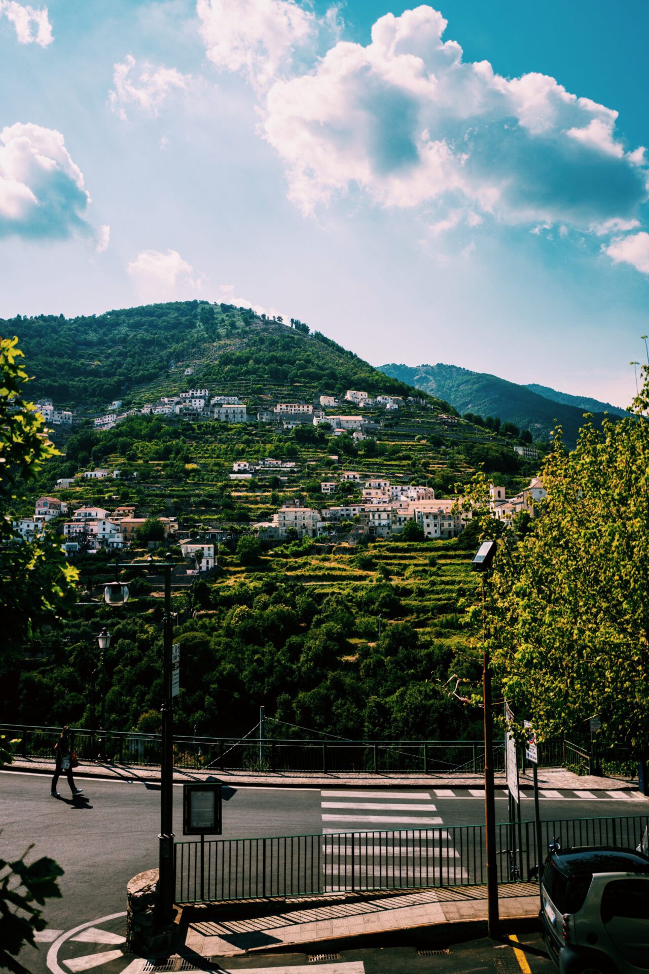 Houses over a green hill surrounded by plants and trees facing the ocean with steps levels on the mountains at Ravello Campania in Italy