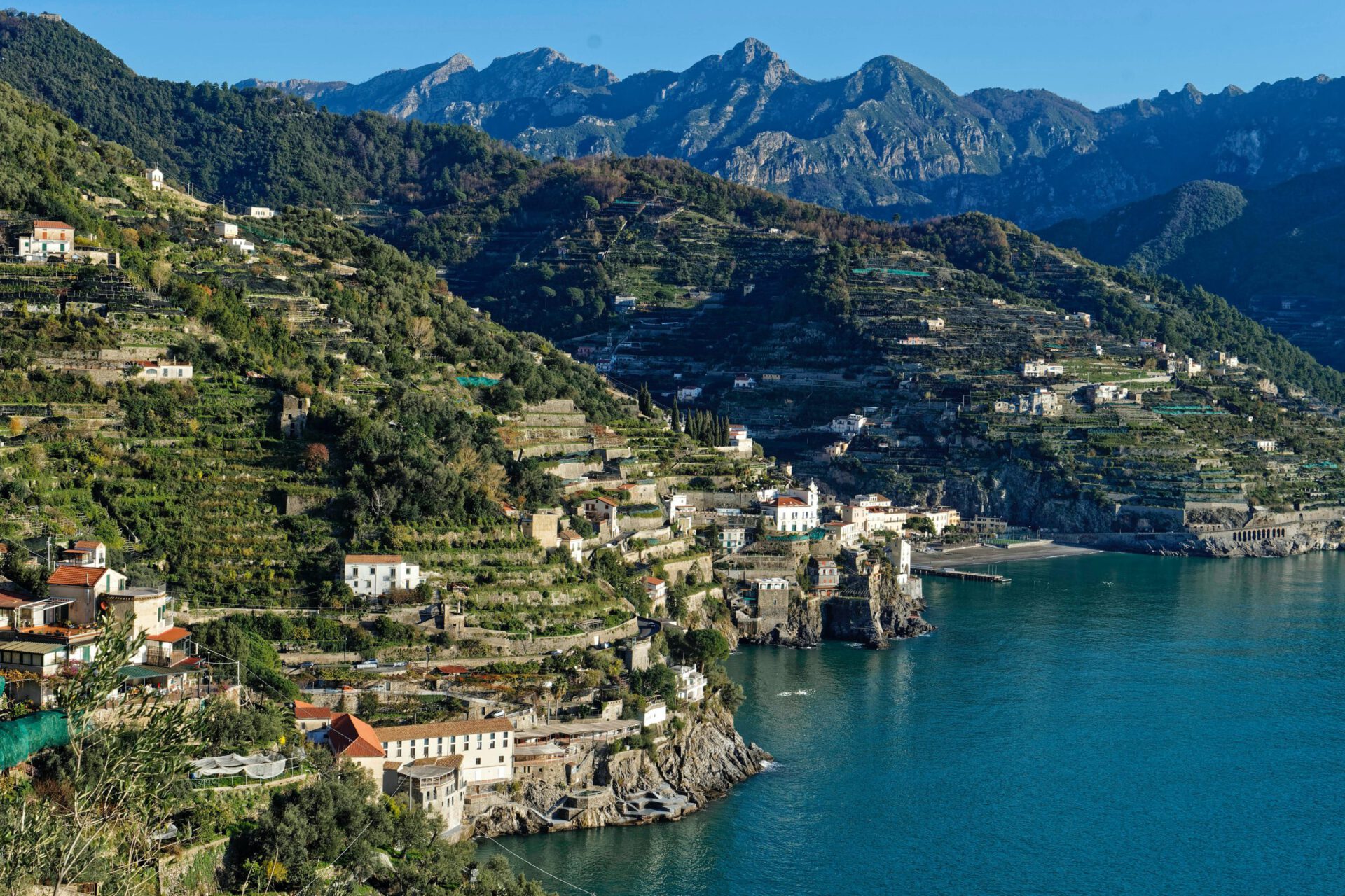 Houses over a green hill surrounded by plants and trees facing the ocean with steps levels on the mountains at Ravello Campania in Italy