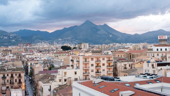 an ariel view of the city of Palermo wit the mountain in the background