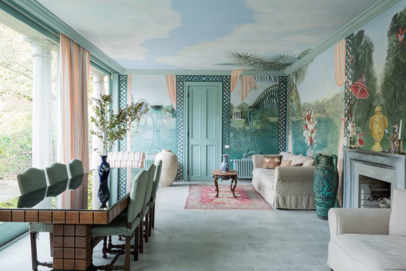 an internal room at La Foleia with a large dining table and beautiful frescos on the walls