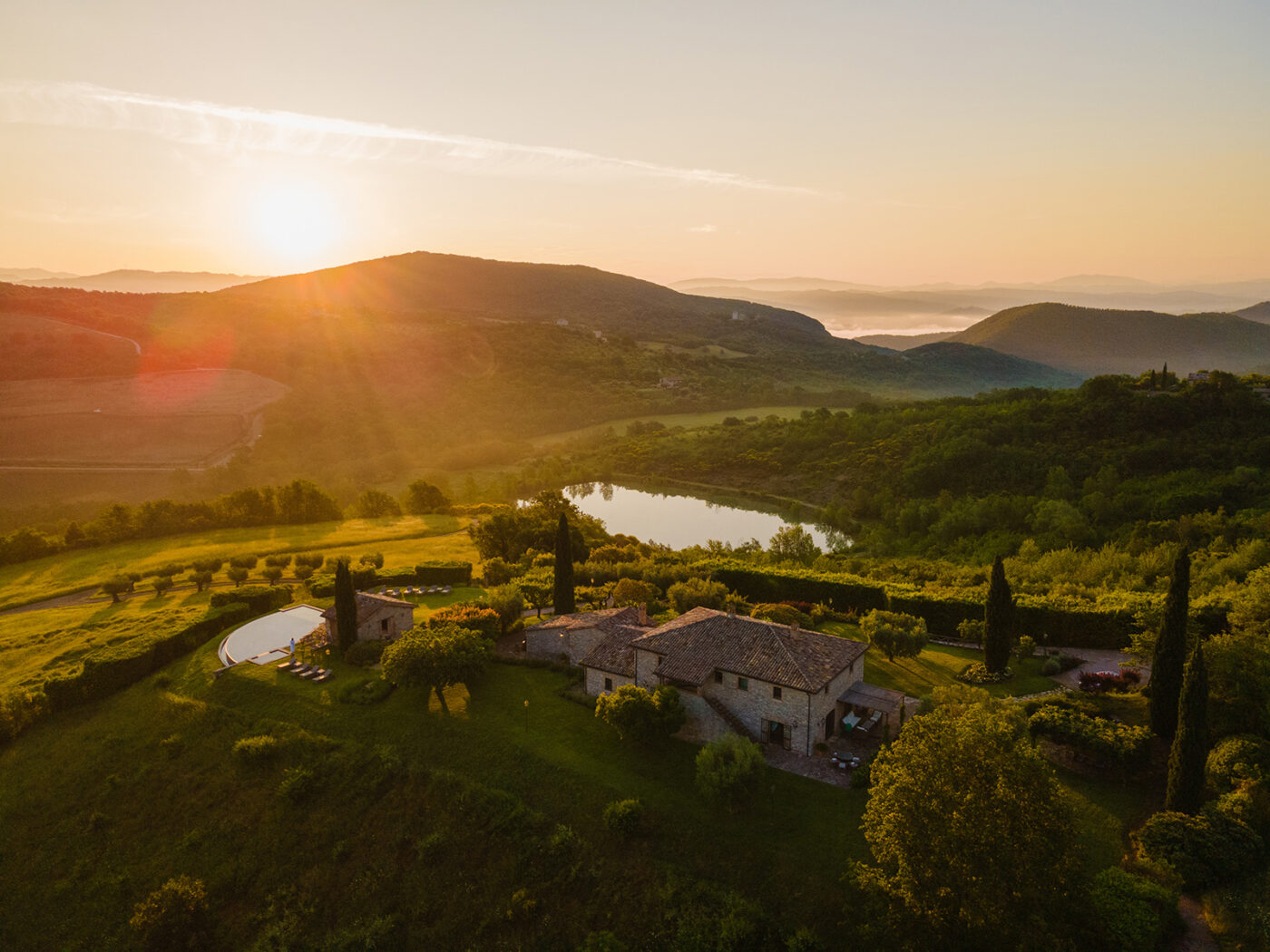 an aerial image of Tenuta di Murlo with sunset over the surrounding hills
