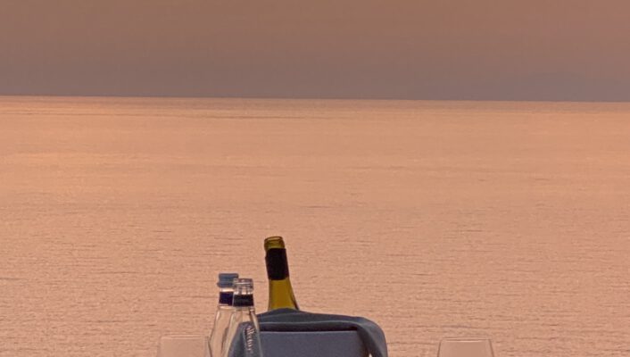 wine glasses against the sea at sunset in Sardinia, Italy