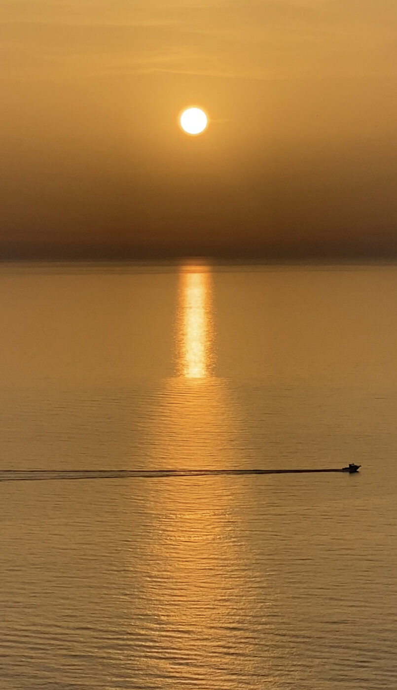 sunset over the sparkling sea in Sardinia, Italy