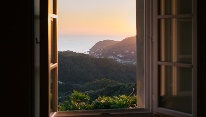 a view of a sunset over the sea out the window of La Sosta di Ottone III
