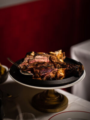 Bistecca alla fiorentina sliced and arranged on an elevated plate in a Tuscan restaurant