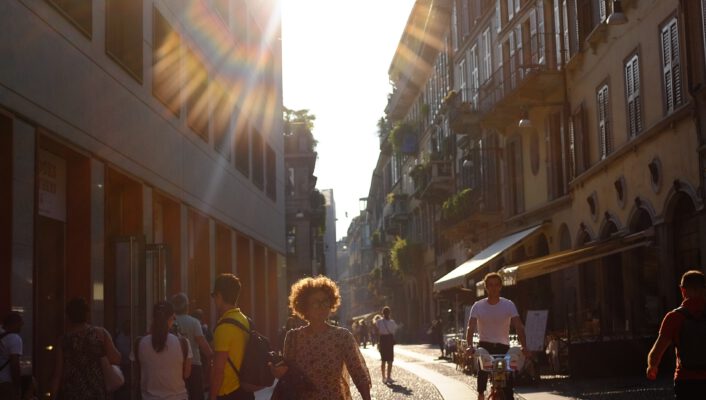 a street in Brera Milan with the sun bright in the sky and the street darkened