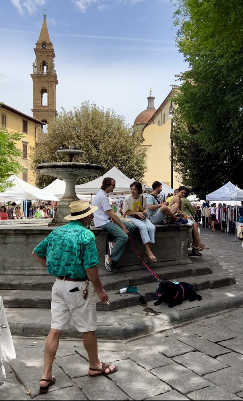 people sitting around the fountain at piazza santo spirito