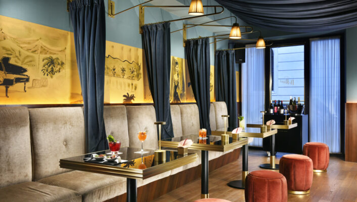 small tables along one large booth at the bar at Hotel Dè Ricci