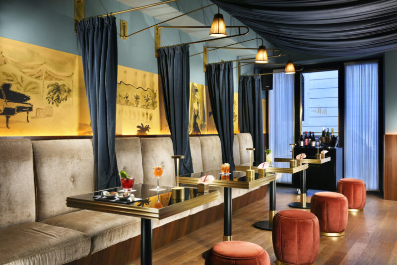 small tables along one large booth at the bar at Hotel Dè Ricci